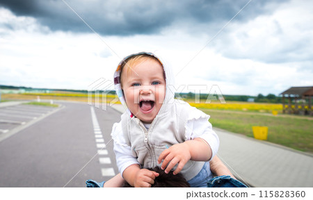 Laughing Baby Boy On Mom'S Shoulders On A Road, Looking Sweet Laughing Baby Boy On Mom'S Shoulders On A Road, Looking Sweet 115828360
