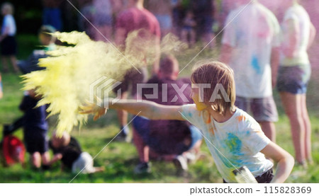 Small Girl Tossing Vibrant Colored Powder Paint In The Air During A Holi Festival Small Girl Tossing Vibrant Colored Powder Paint In The Air During A Holi Festival 115828369