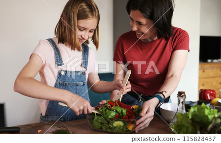Mother Teaching Her Cute Beautiful Daughter To Cook A Vegetable Salad 115828437