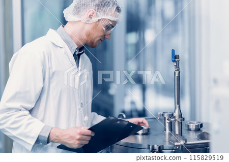Scientist Medical Factory Staff Working in Science Lab. Medicine factory Technician Employee Check Care Products Quality in Sterilize Room Taking Note in Check list. 115829519