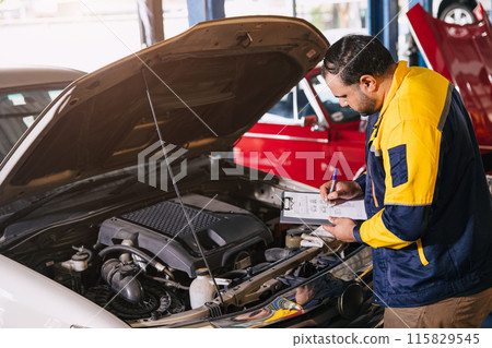 mechanic man checking engine open hood looking check list car maintenance service in garage workshop mechanic man checking engine open hood looking check list car maintenance service in garage workshop 115829545