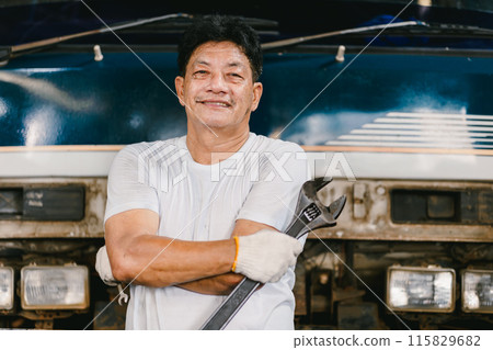 Portrait Auto Mechanic working in Garage Car service workshop. Confident workman arm crossing. 115829682