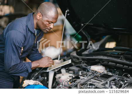 Garage professional working auto service checking engine. Mechanic man using tablet computer tuning car ECU. 115829684