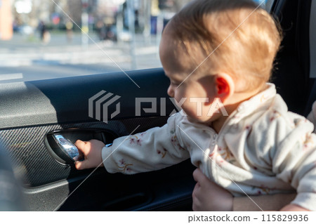 An independent child tries to open a car door from the inside 115829936