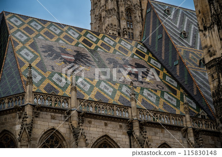 Vienna,Austria,August 18, 2022. Detail of the roof of St. Stephen's Cathedral. The use of colored tiles as cladding creates eye-catching designs and patterns. The national coats of arms are prominent Vienna,Austria,August 18, 2022. Detail of the roof of St. Stephen's Cathedral. The use of colored tiles as cladding creates eye-catching designs and patterns. The national coats of arms are prominent 115830148