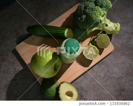 Green smoothie in bottle with avocado lime, broccoli, apple, cucumber. Perfect smoothie for detox, health, and wellness content. smoothie ingredients for vibrant, nutritious lifestyle. 115830862