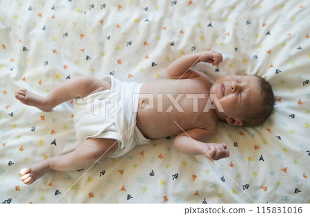 Portrait of cute little baby lying on bed, wearing diaper. Portrait of cute little baby lying on bed, wearing diaper. 115831016