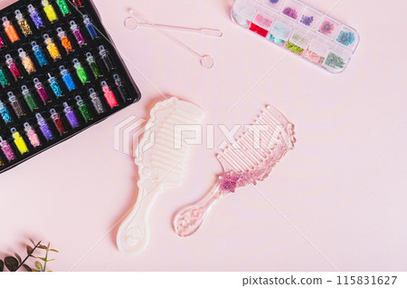 Epoxy resin comb, mold and glitter for making on a pink background top view Epoxy resin comb, mold and glitter for making on a pink background top view 115831627