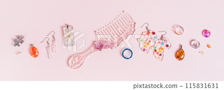 Earrings, pendants, rings, comb and other jewelry made of epoxy resin on a pink top view web banner Earrings, pendants, rings, comb and other jewelry made of epoxy resin on a pink top view web banner 115831631