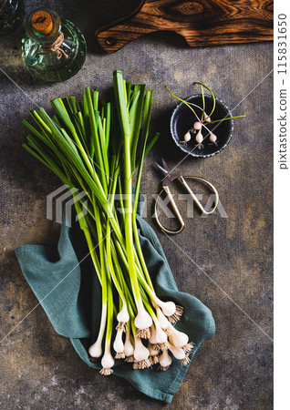 New trendy vegetable sweet garleek on a cloth on the table top and vertical view New trendy vegetable sweet garleek on a cloth on the table top and vertical view 115831650