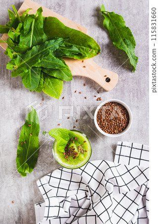 Detox smoothie made from green sorrel and flax seeds in a glass on the table top and vertical view Detox smoothie made from green sorrel and flax seeds in a glass on the table top and vertical view 115831660