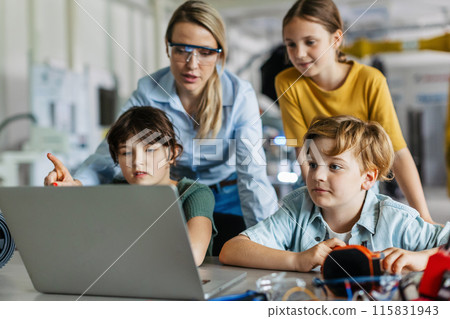 Children learning robotics in Elementary school. Young students programming, building robot in after school robotics club. Field trip to real robotics laboratory. 115831943