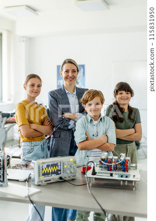 Children learning robotics in Elementary school. Young students building robot in after school robotics club. Field trip to real robotics laboratory. 115831950