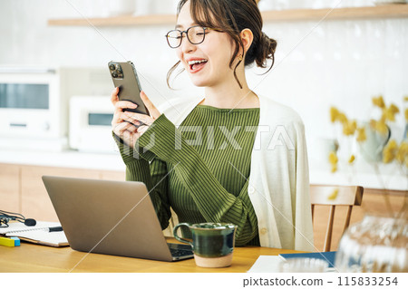 一個女人在客廳裡看著她的智能手機 115833254