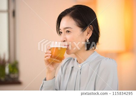 A middle-aged woman drinking beer with relish A middle-aged woman drinking beer with relish 115834295