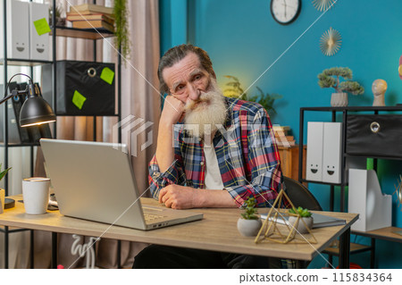 Thoughtful senior man looking away thinking solving problem with laptop make decision lack of ideas 115834364