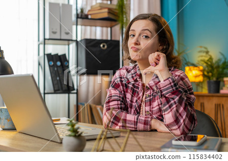Businesswoman working on laptop computer at home office showing thumbs down sign dislike disapproval Businesswoman working on laptop computer at home office showing thumbs down sign dislike disapproval 115834402