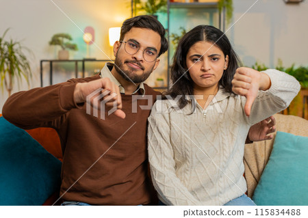 Upset Indian couple showing thumbs down gesture, expressing discontent, disapproval, dissatisfied 115834488