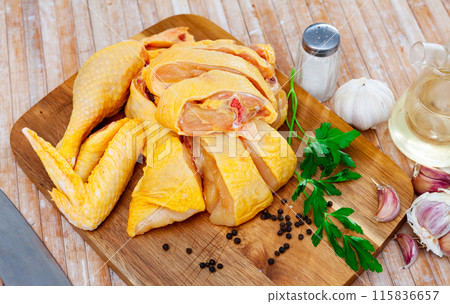 Raw chicken with condiments on kitchen table 115836657