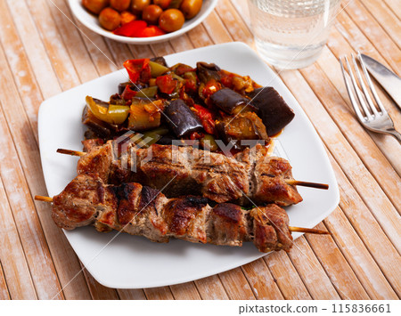 Grilled pork meat shashlik with sauteed vegetables 115836661