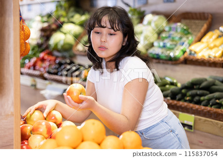 Young asian girl selecting ripe apples in supermarket Young asian girl selecting ripe apples in supermarket 115837054