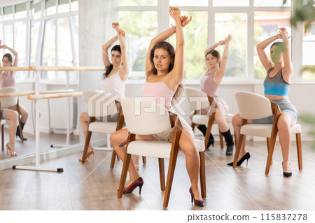 Fit young woman performing exotic chair dance at group class Fit young woman performing exotic chair dance at group class 115837278