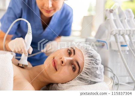 Female client undergoing anti-aging ultrasonic phonophoresis procedure on decollete Female client undergoing anti-aging ultrasonic phonophoresis procedure on decollete 115837304