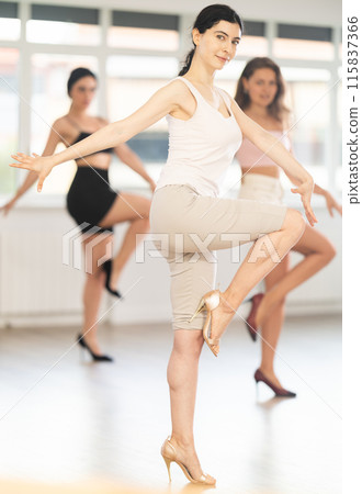 During lesson, girl learn to move and perform dance in heels with women companions 115837366