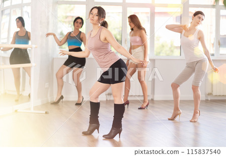 Dynamic female dancers rehearsal, performing sensual choreography in high heels, epitomizing grace in studio Dynamic female dancers rehearsal, performing sensual choreography in high heels, epitomizing grace in studio 115837540