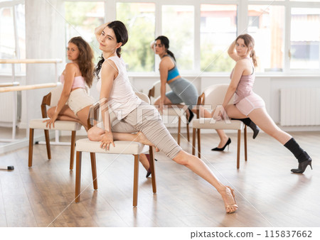 Slender women rehearse modern dances using chair Slender women rehearse modern dances using chair 115837662