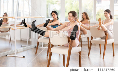 Female dancers wearing high heels shoes stretching legs while practicing in studio before dance performance providing 115837860