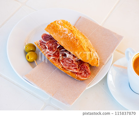 Sandwich with fuet sausage and olives. Spanish breakfast Sandwich with fuet sausage and olives. Spanish breakfast 115837870