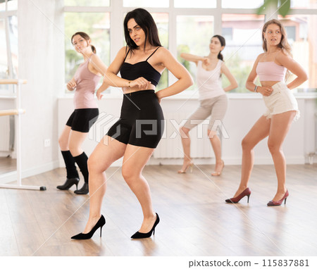 During lesson, girl learn to move and perform dance in heels with women companions 115837881