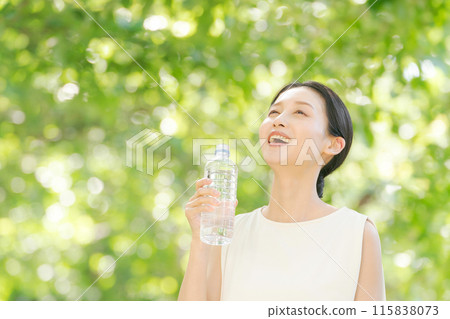 A woman drinking water of a plastic bottle 115838073