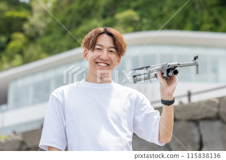 Japanese man enjoying drone photography outdoors on a sunny day | Drone image 115838136