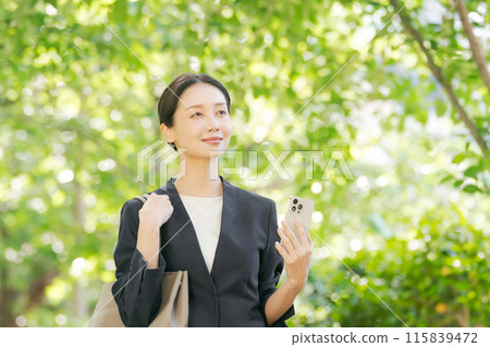 A woman with a suit with a smartphone A woman with a suit with a smartphone 115839472
