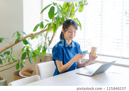 A woman in a polo shirt working in an office 115840237