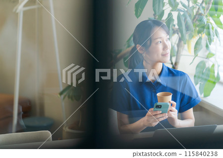 A woman in a polo shirt working in an office 115840238