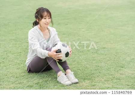 A Japanese woman who is a soccer fan and supporter with a soccer ball on the playground A Japanese woman who is a soccer fan and supporter with a soccer ball on the playground 115840769