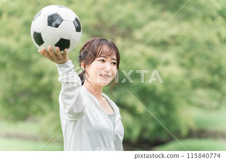 A Japanese woman who is a soccer fan and supporter with a soccer ball on the playground 115840774
