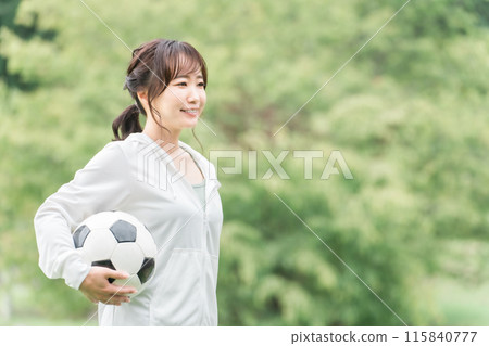 A Japanese woman who is a soccer fan and supporter with a soccer ball on the playground A Japanese woman who is a soccer fan and supporter with a soccer ball on the playground 115840777