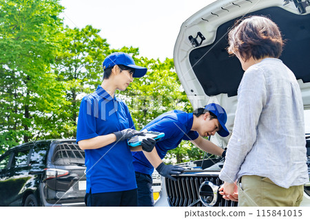 Worker checking the engine compartment of a car 115841015