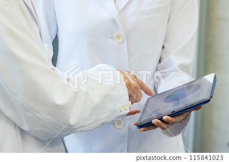 醫生和研究人員一邊看平板電腦一邊諮詢 115841023