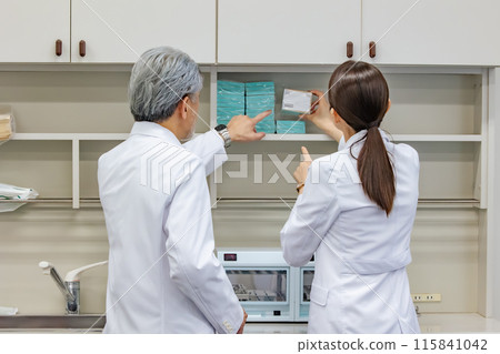 身穿白大褂的技術人員檢查貨架 身穿白大褂的技術人員檢查貨架 115841042
