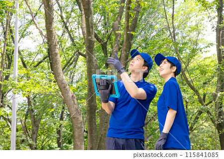 A worker surveying the forest using a tablet A worker surveying the forest using a tablet 115841085