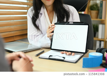 Physical therapist having a conversation with patient while explaining something on digital tablet Physical therapist having a conversation with patient while explaining something on digital tablet 115841308
