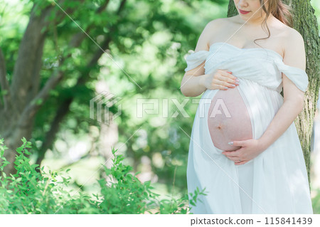 Asian pregnant women taking maternity photos (Sunlight filtering through foliage) Asian pregnant women taking maternity photos (Sunlight filtering through foliage) 115841439