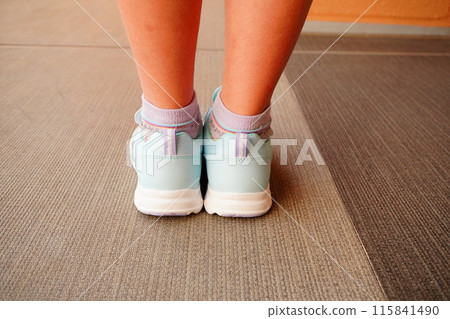 Waterproof sneakers for rainy days. A fifth grade girl is seen wearing them. 115841490