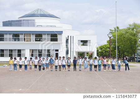 First-year students lined up in front of the school building with their backpacks on. First-year students lined up in front of the school building with their backpacks on. 115843077