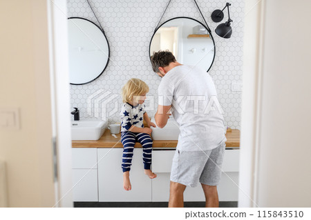 Father brushing son's teeth. Morning routine for young boy before going to preschool. 115843510